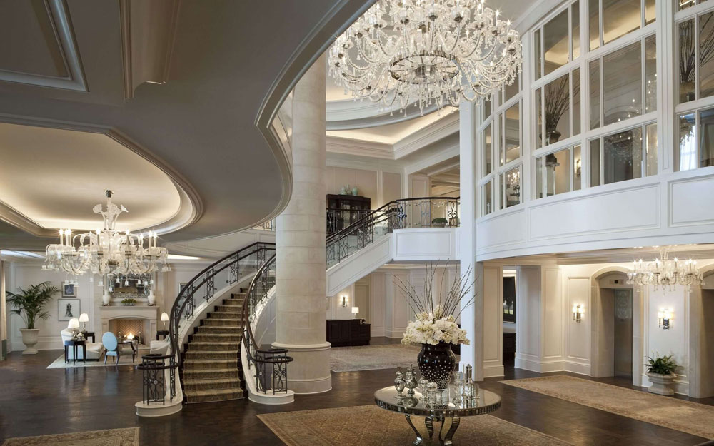interior design space with chandelier and mirrored furniture with a long step of stairs 